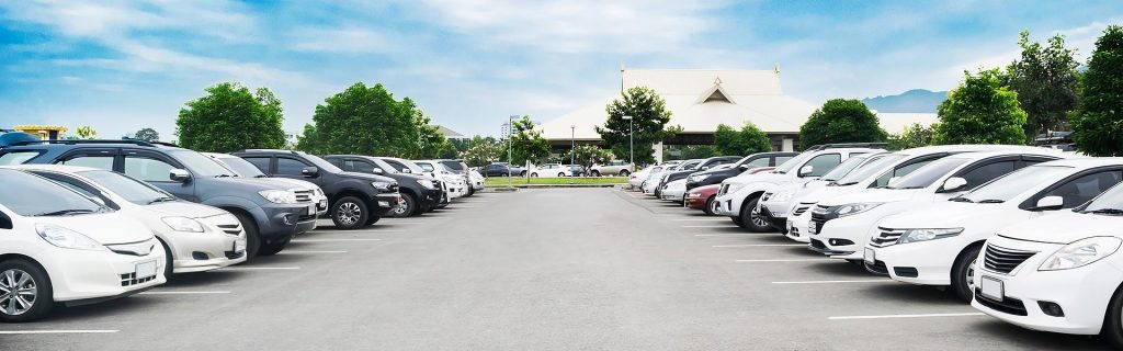 Rows of vehicles parked in an outdoor parking lot.
