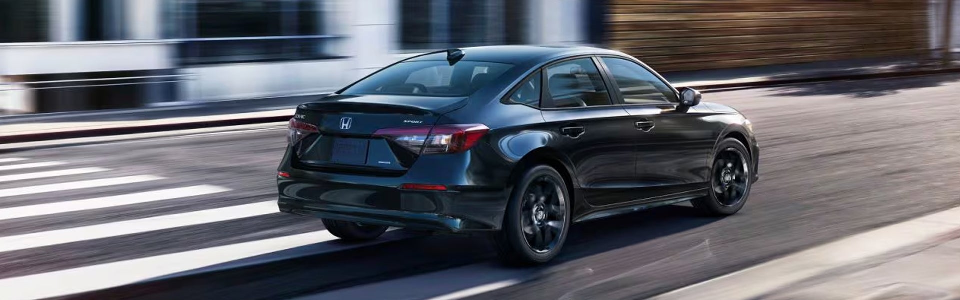 Dark blue Honda Civic sedan driving on an urban street